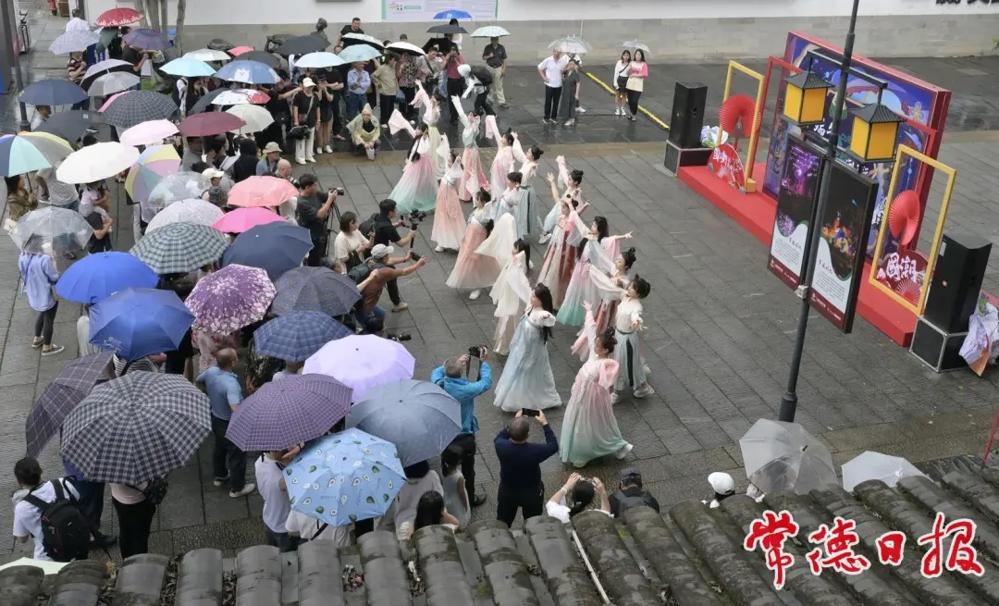 2024年端午期间，常德河街国风表演吸引到众多游客撑伞欣赏。（常德日报媒资库）